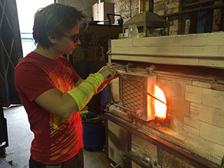 Gathering glass from the furnace to create a christmas bauble tree decoration